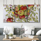 Three-panel canvas wall art featuring apples hanging from branch, displayed in a modern living room above seating.