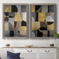Set of two gray barnwood framed canvas prints depicting a coordinated art pair of interlocking black gray cream and gold geometric sections rendered as structured modern abstracts above a dining room sideboard.