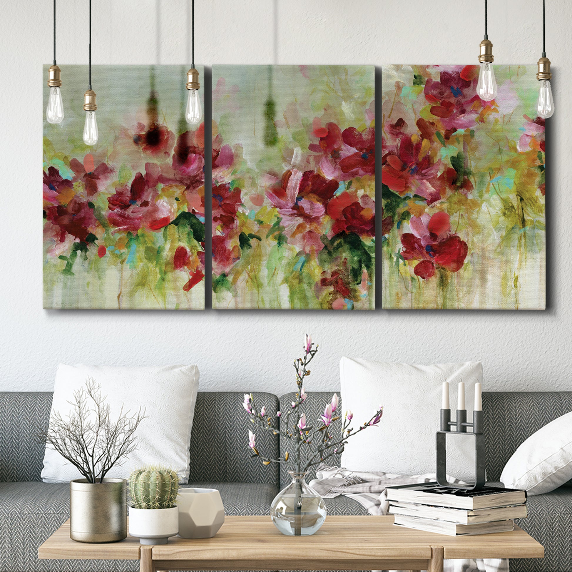 Three-panel canvas wall art featuring colorful floral garden composition, displayed in a modern living room above seating.