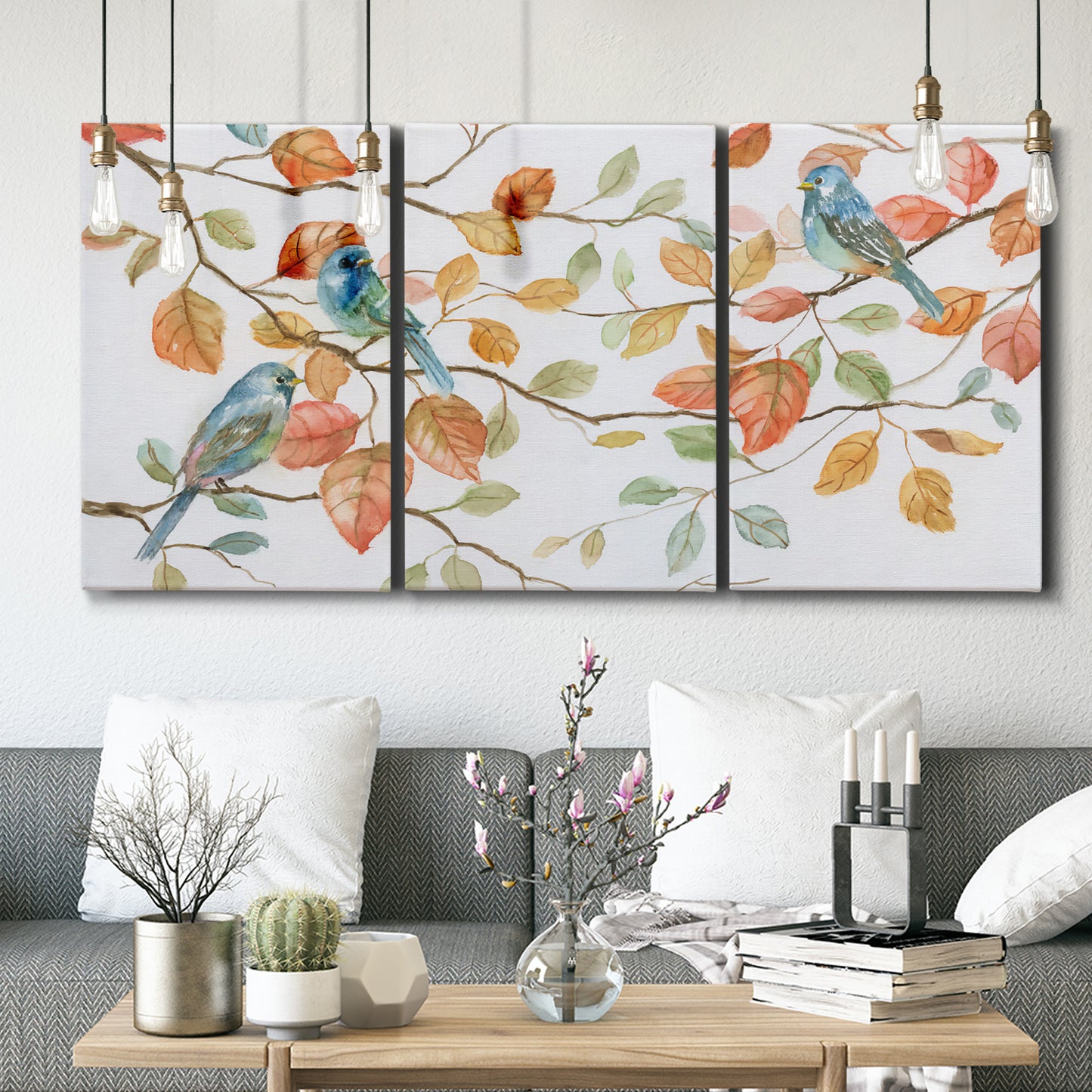 Three-panel canvas wall art featuring decorative bird trio illustration, displayed in a modern living room above seating.