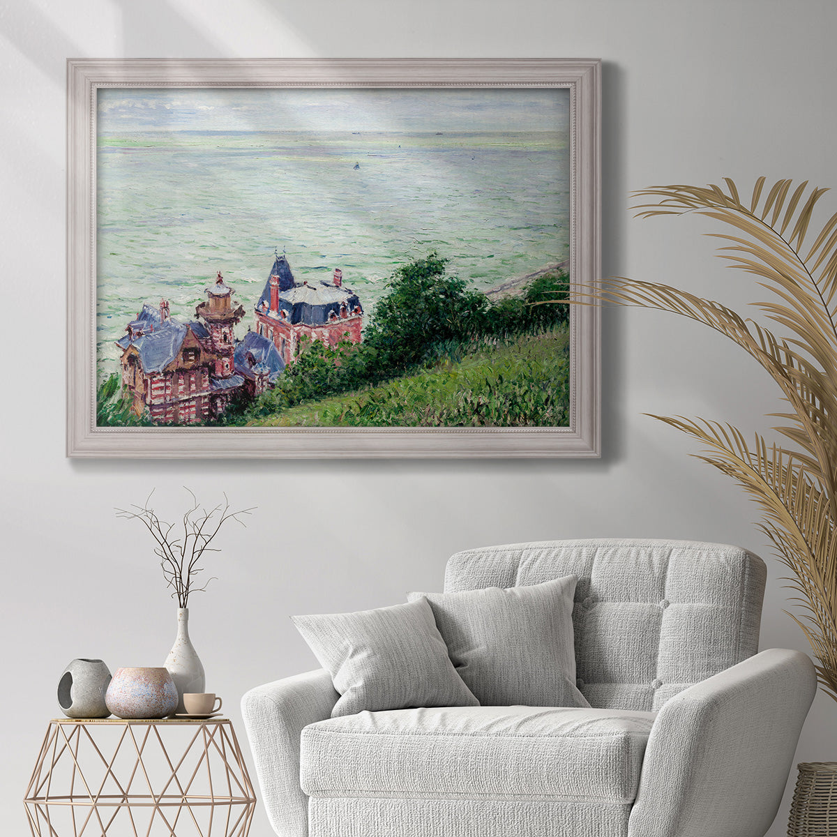 Impressionist coastal villas landscape by Gustave Caillebotte in an ornate weathered white frame displayed in a bright interior setting.