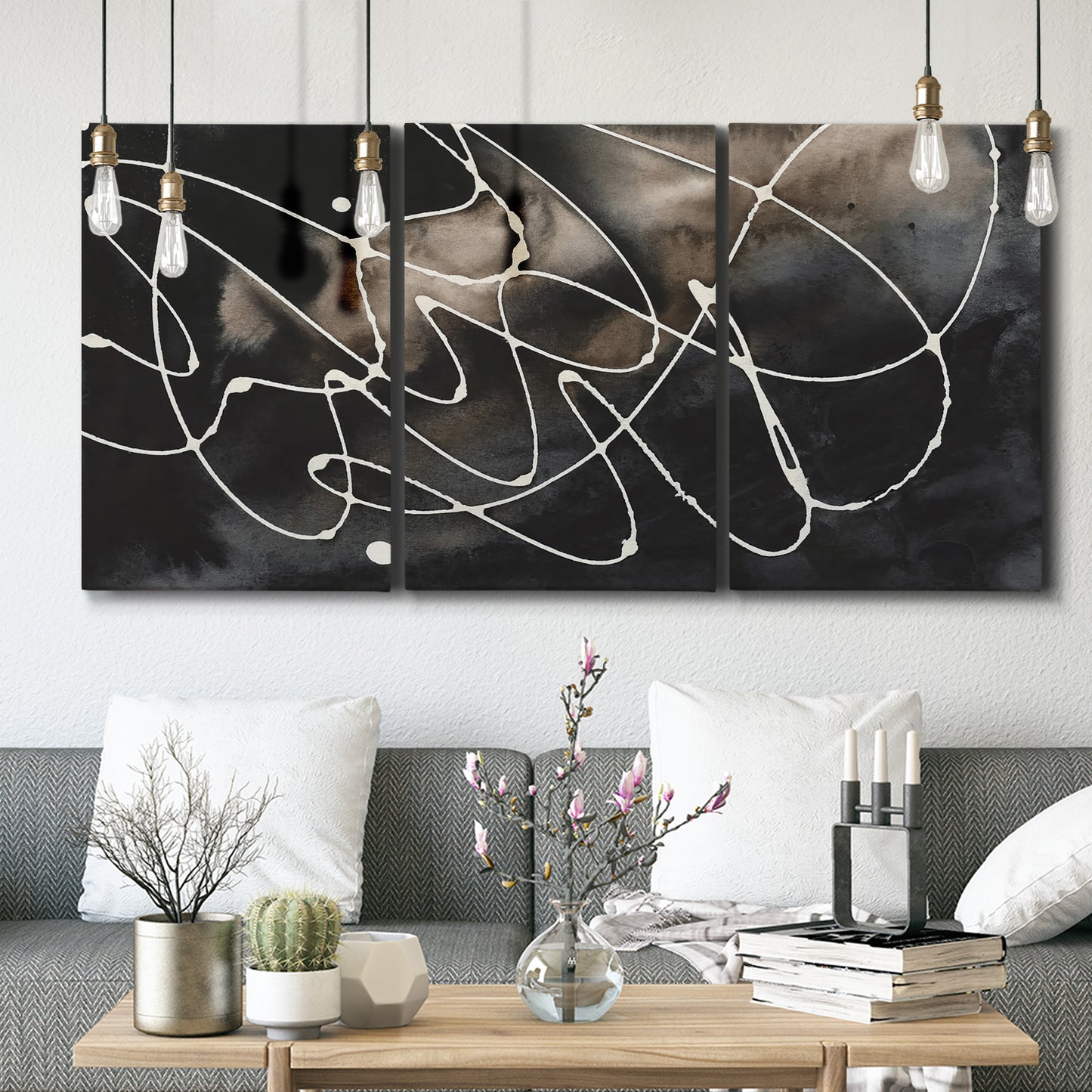 Three-panel canvas wall art featuring dark swirling abstract motion, displayed in a modern living room above seating.