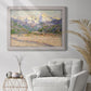 Impressionist valley landscape in southern France by Claude Monet in an ornate weathered white frame displayed in a bright interior setting.