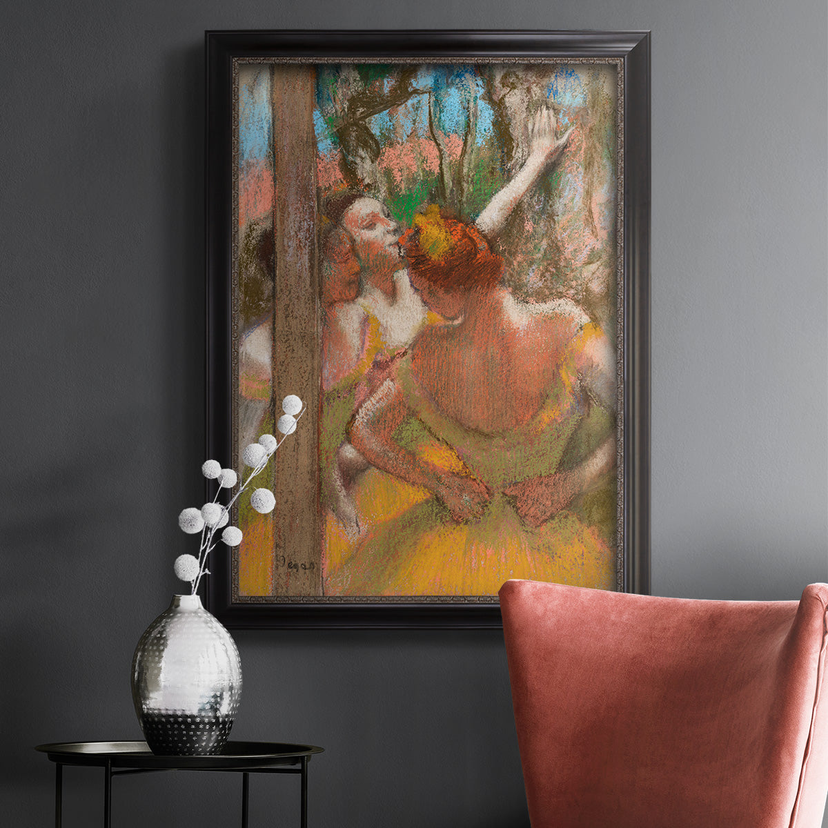 Impressionist ballet dancer composition by Edgar Degas in an ornate black frame with gilded inner detail displayed in a dark-toned interior setting.