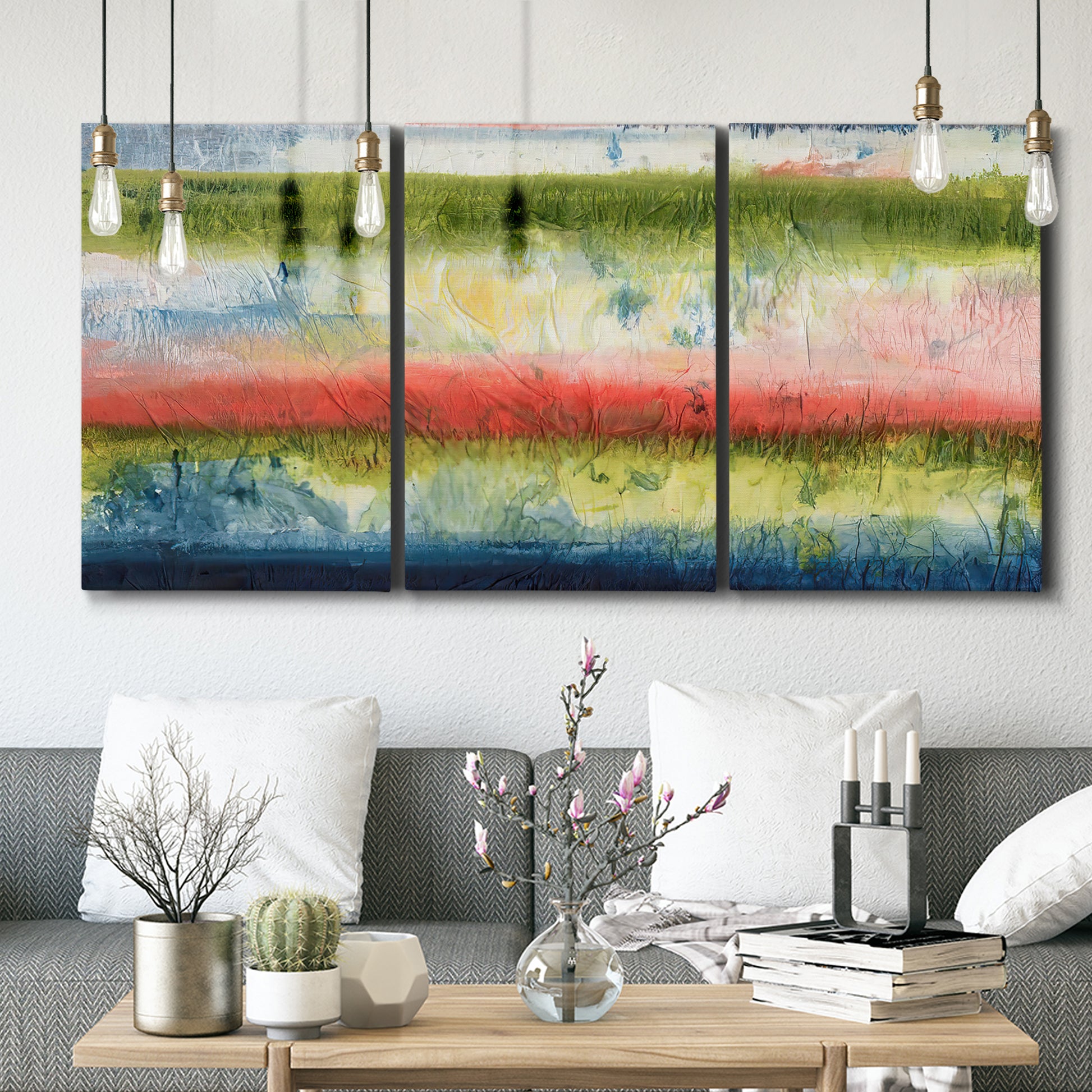 Three-panel canvas wall art featuring layered abstract color banding, displayed in a modern living room above seating.