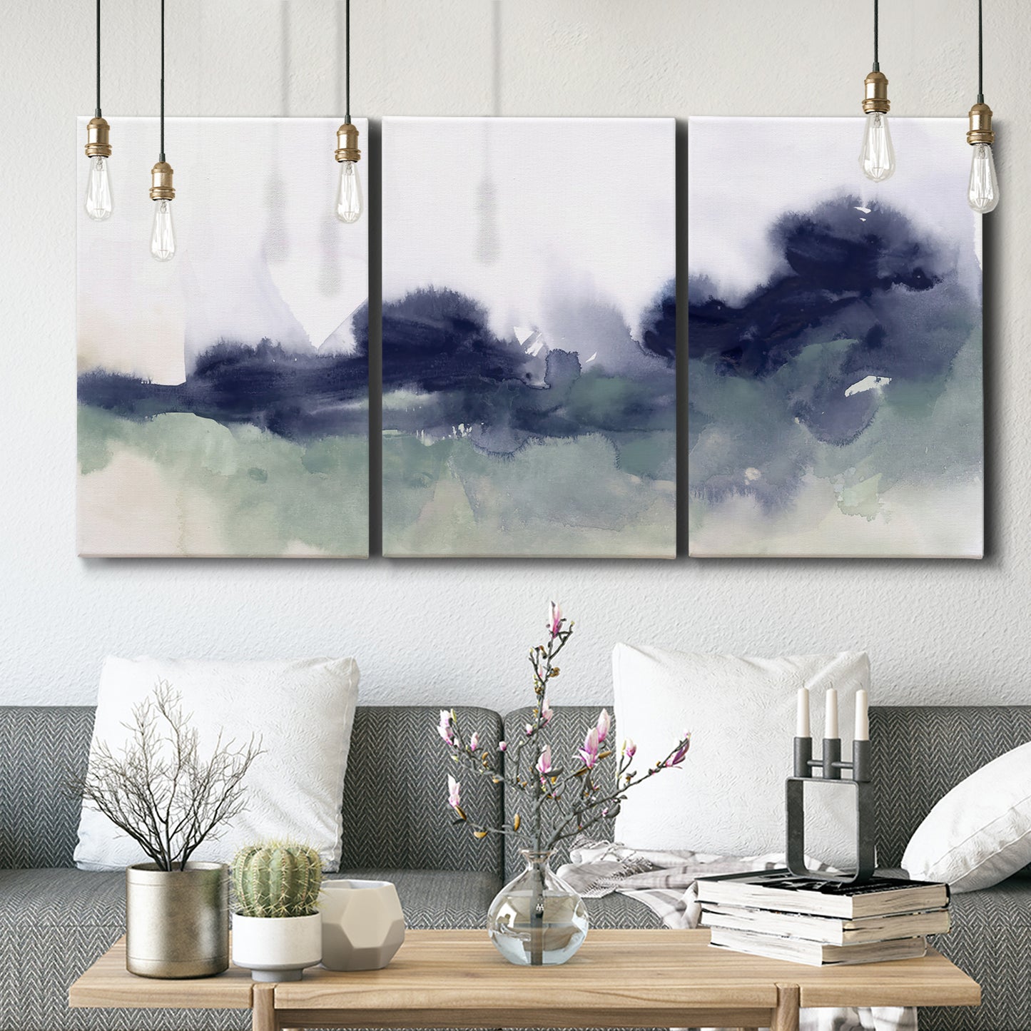 Three-panel canvas wall art featuring misty abstract lake watercolor, displayed in a modern living room above seating.