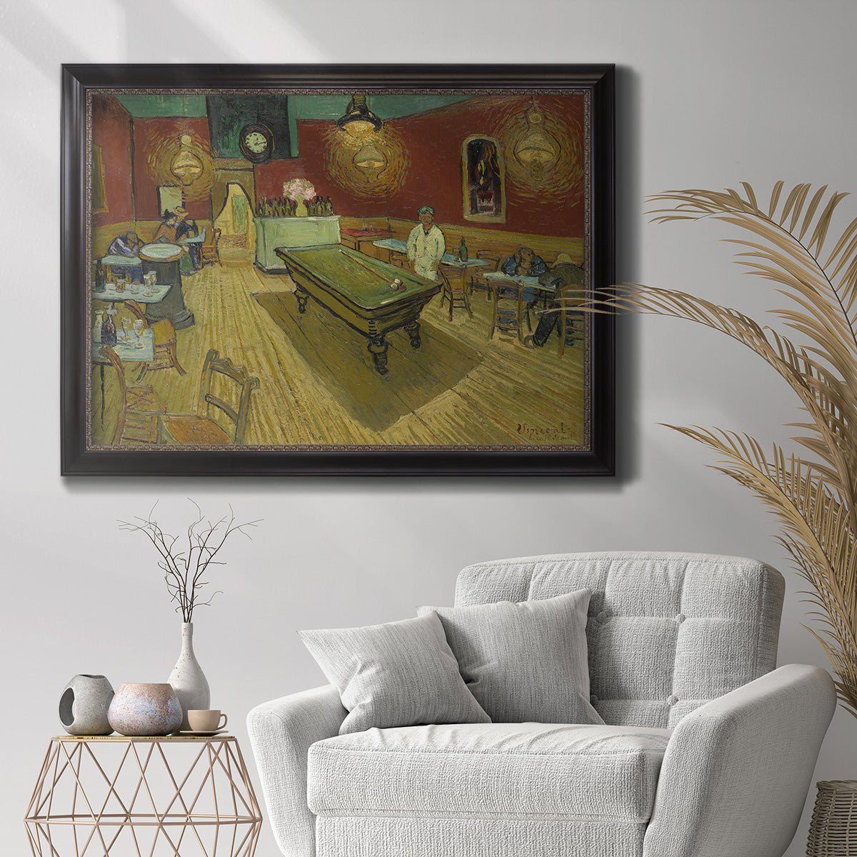 Impressionist interior of a night café by Vincent van Gogh in an ornate black frame with gilded inner detail displayed in a bright interior setting.