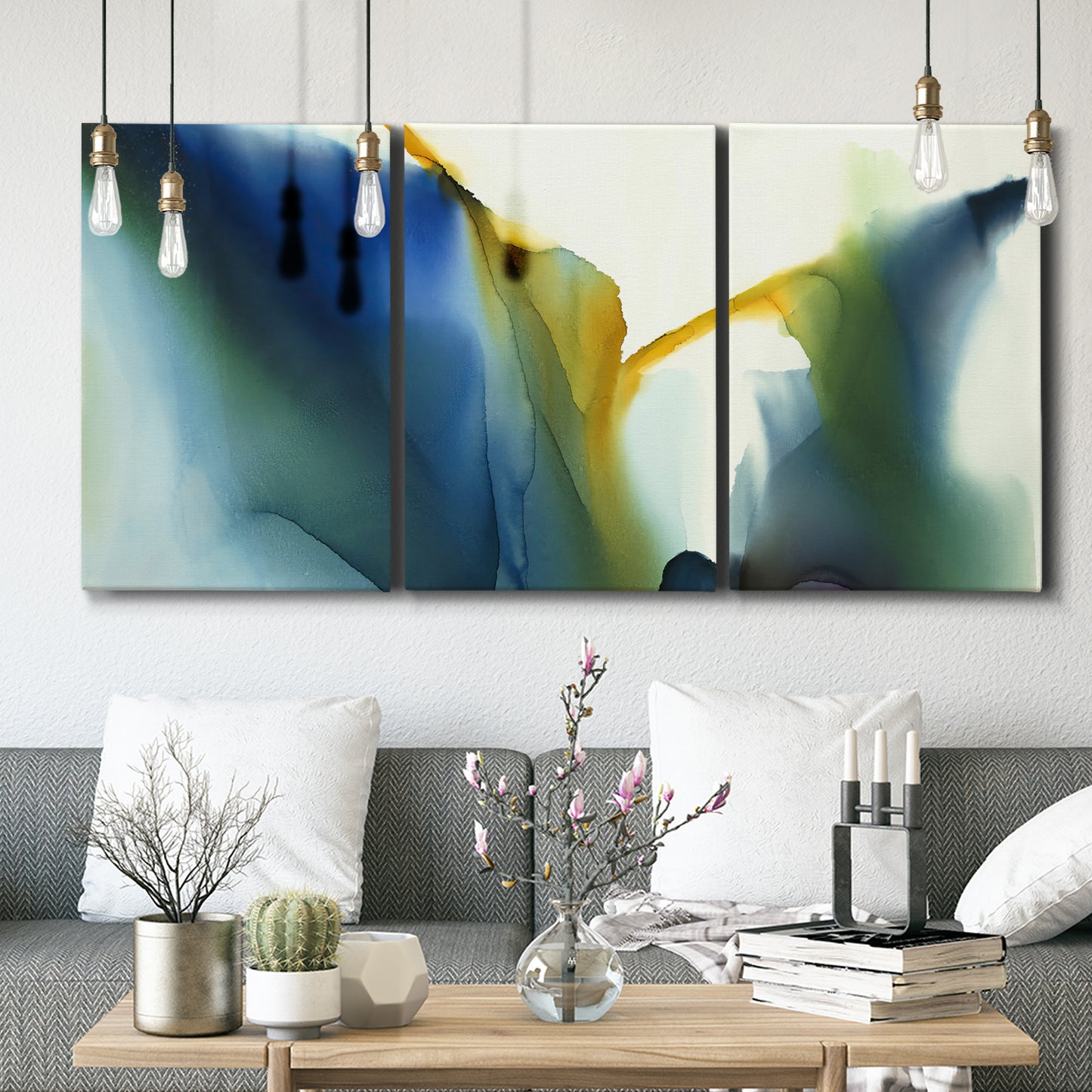 Three-panel canvas wall art featuring soft abstract mask like forms, displayed in a modern living room above seating.