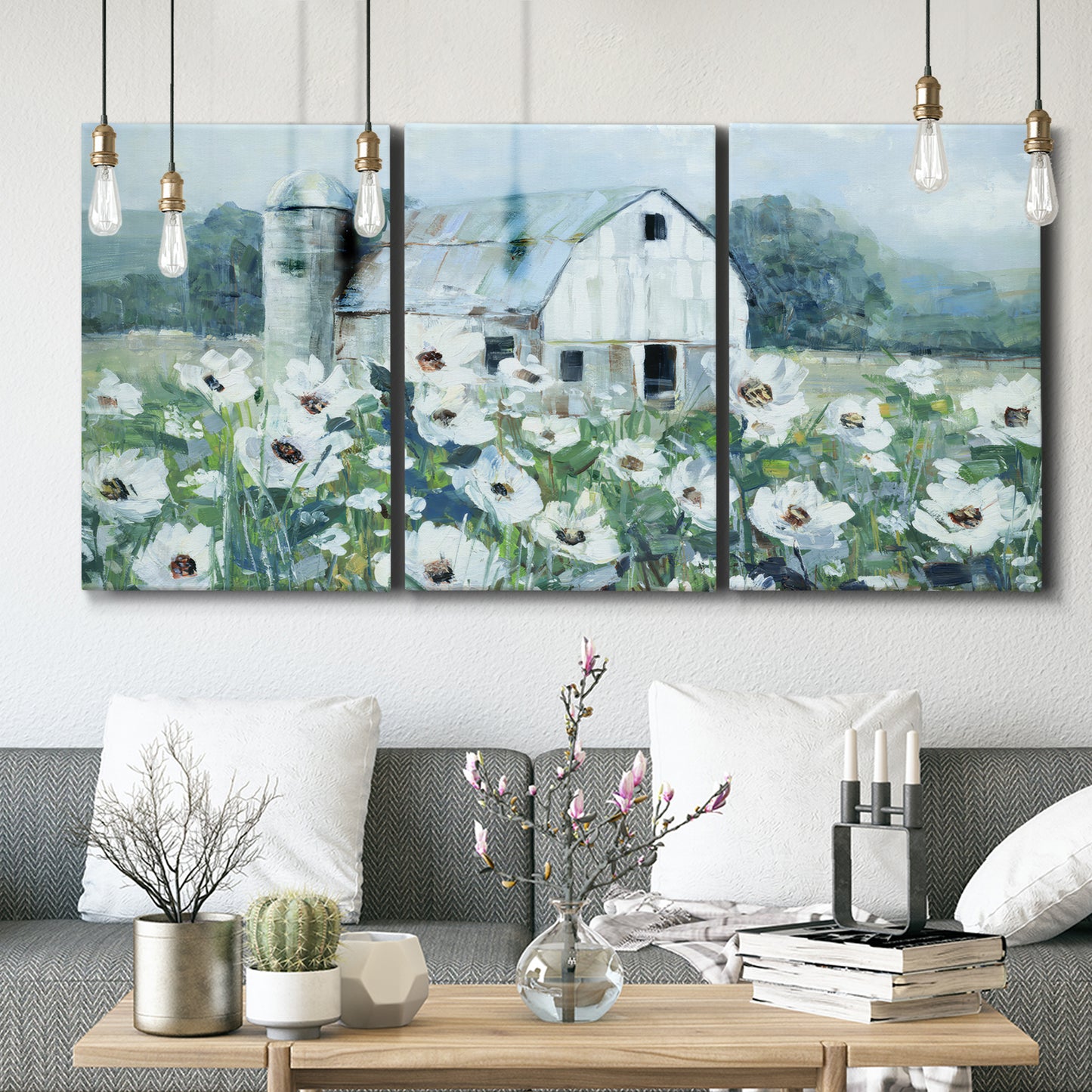 Three-panel canvas wall art featuring pastoral farmland with open fields, displayed in a modern living room above seating.