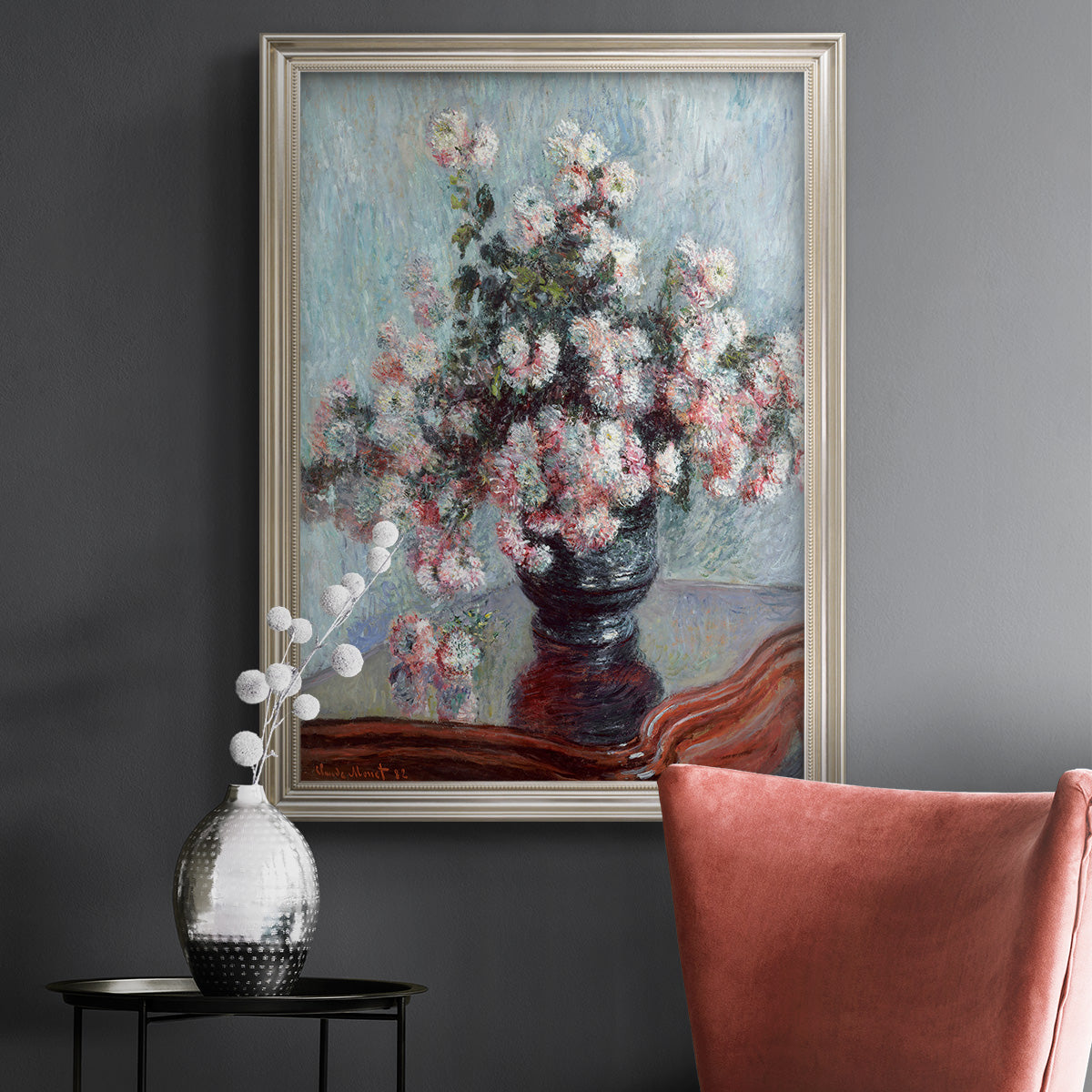 Impressionist chrysanthemum floral painting by Claude Monet in an ornate champagne frame displayed in a dark-toned interior setting.