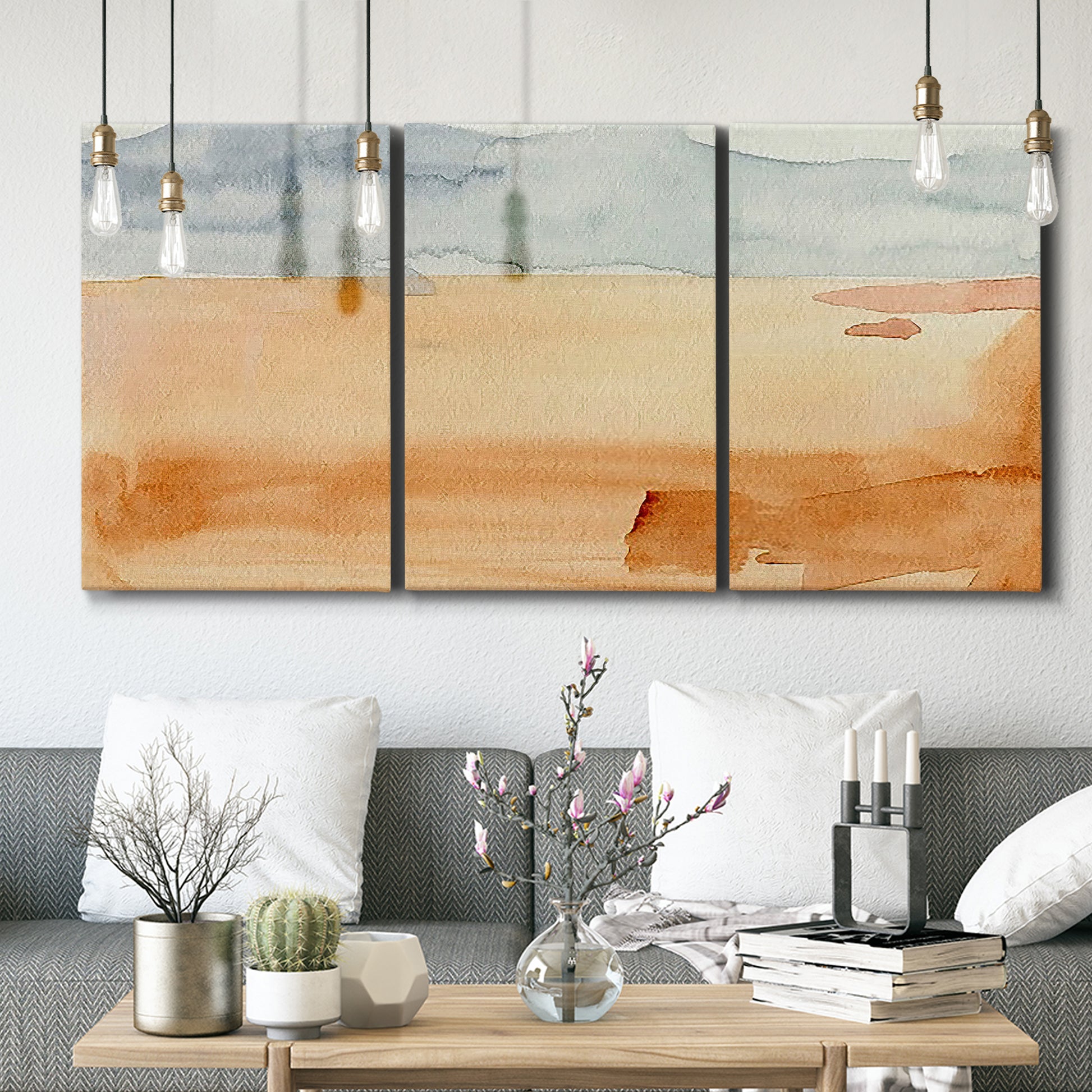 Three-panel canvas wall art featuring minimal horizon with soft blue tones, displayed in a modern living room above seating.