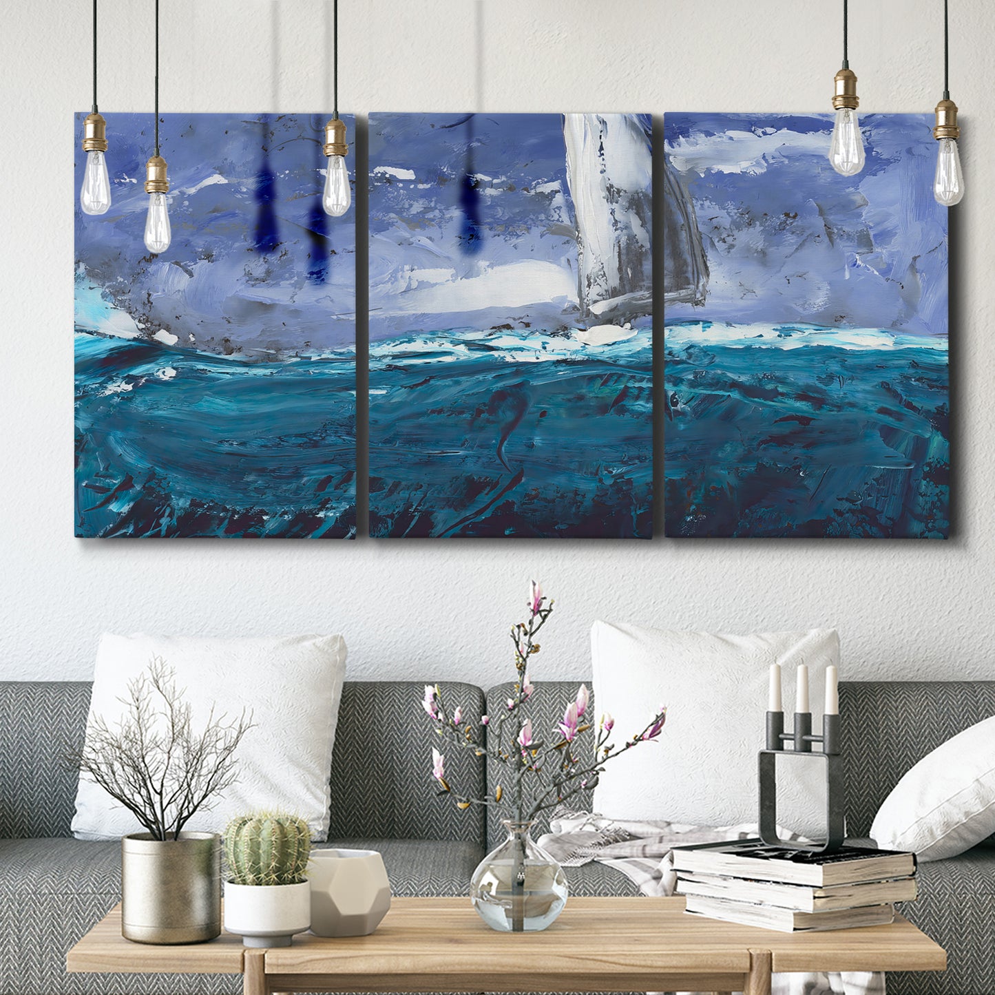 Three-panel canvas wall art featuring sailboats moving across water, displayed in a modern living room above seating.