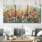 Three-panel canvas wall art featuring colorful garden flowers in bloom, displayed in a modern living room above seating.