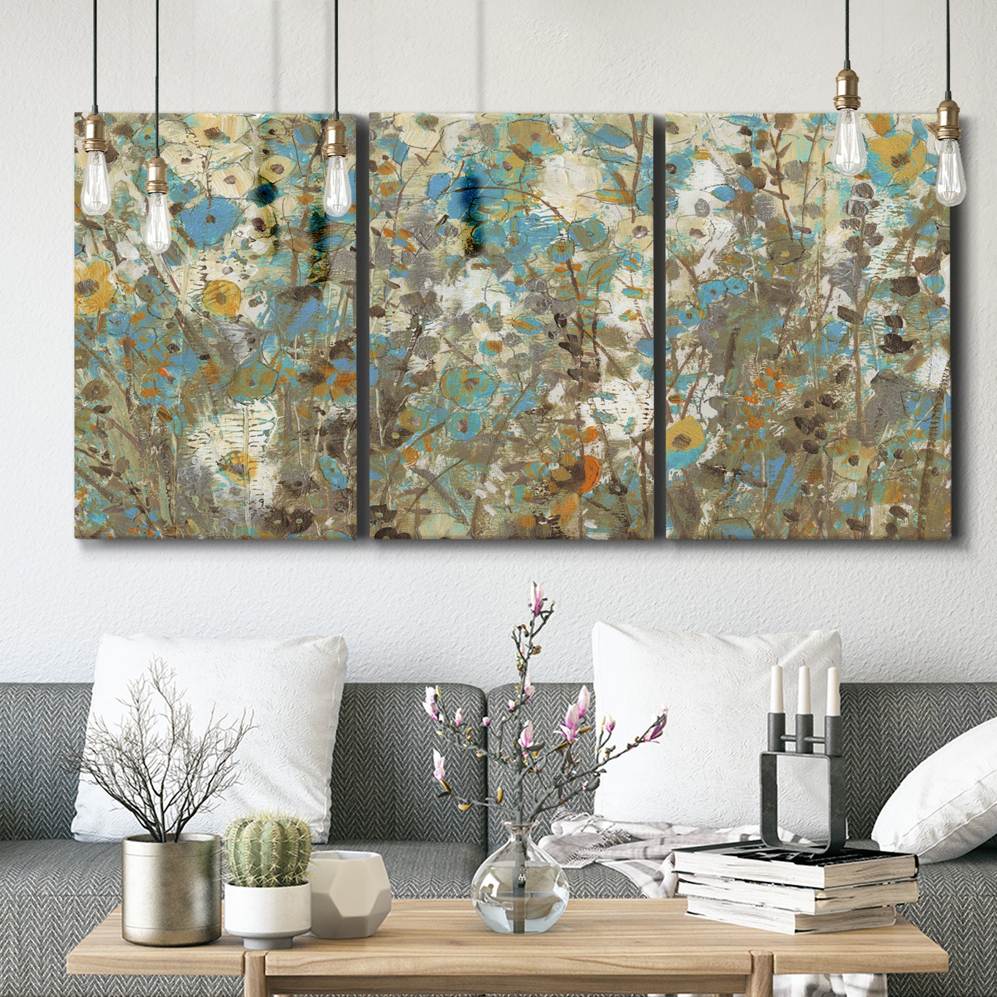 Three-panel canvas wall art featuring abstract flowering vine pattern, displayed in a modern living room above seating.