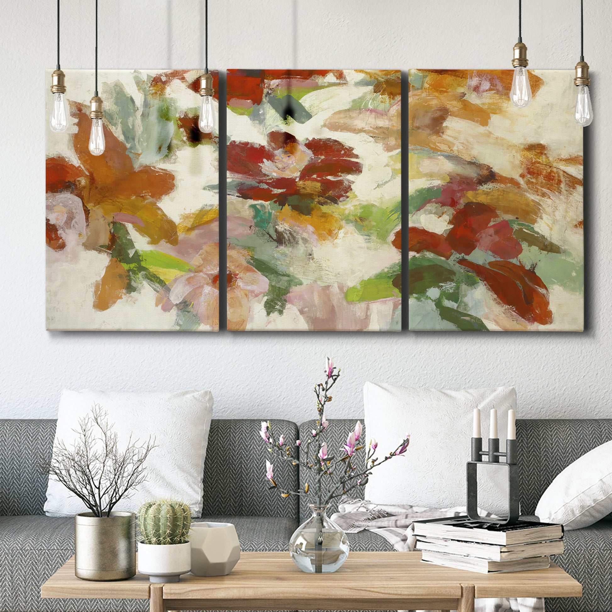 Three-panel canvas wall art featuring layered floral botanical impressions, displayed in a modern living room above seating.