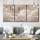 Three-panel canvas wall art featuring soft whimsical cloudscape, displayed in a modern living room above seating.