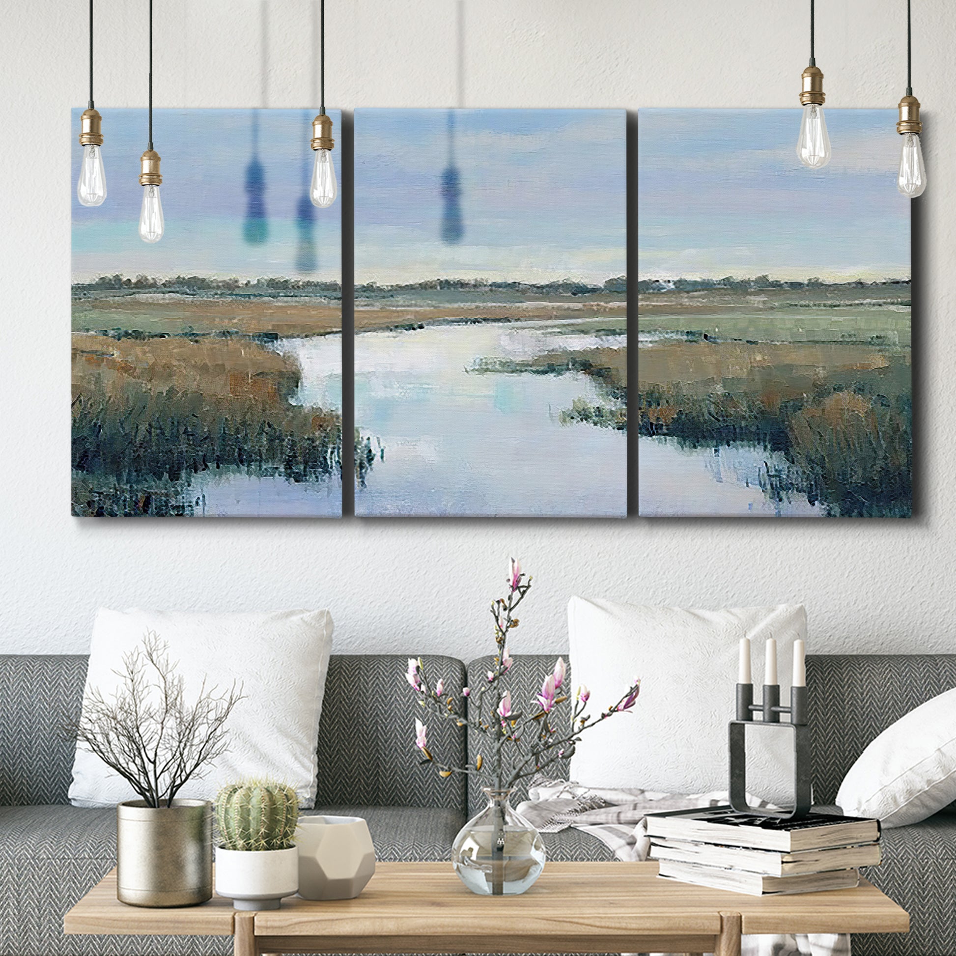 Three-panel canvas wall art featuring coastal plain with layered horizon, displayed in a modern living room above seating.