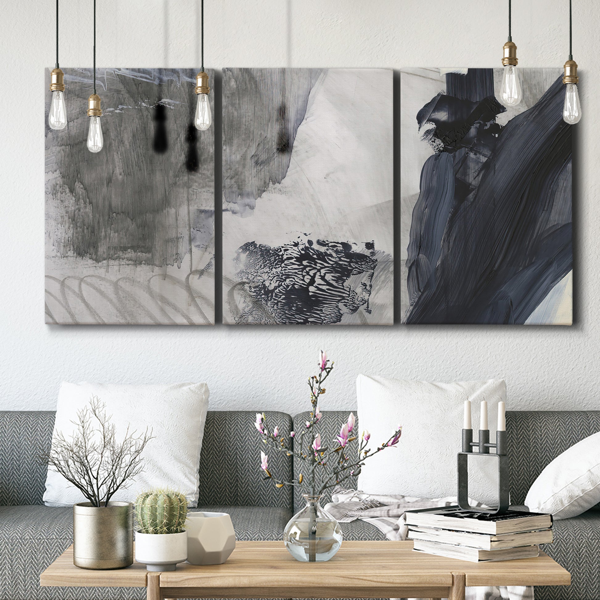 Three-panel canvas wall art featuring dark abstract atmospheric landscape, displayed in a modern living room above seating.