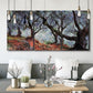 Three-panel canvas wall art featuring pine trees silhouetted at evening, displayed in a modern living room above seating.