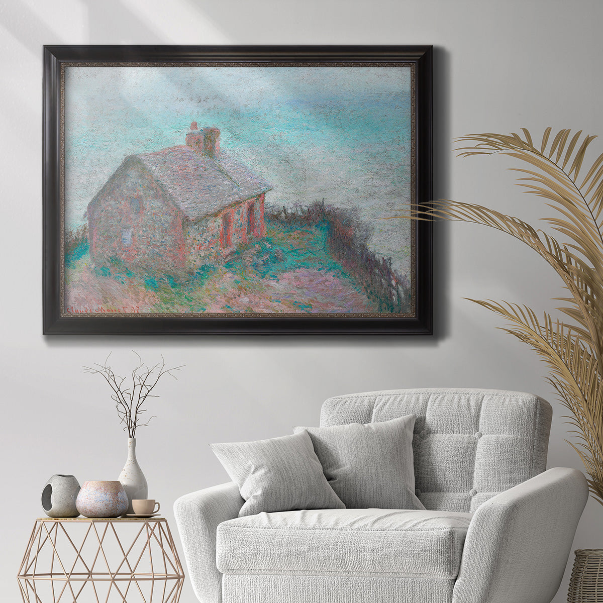 Impressionist coastal building landscape by Claude Monet in an ornate black frame with gilded inner detail displayed in a bright interior setting.