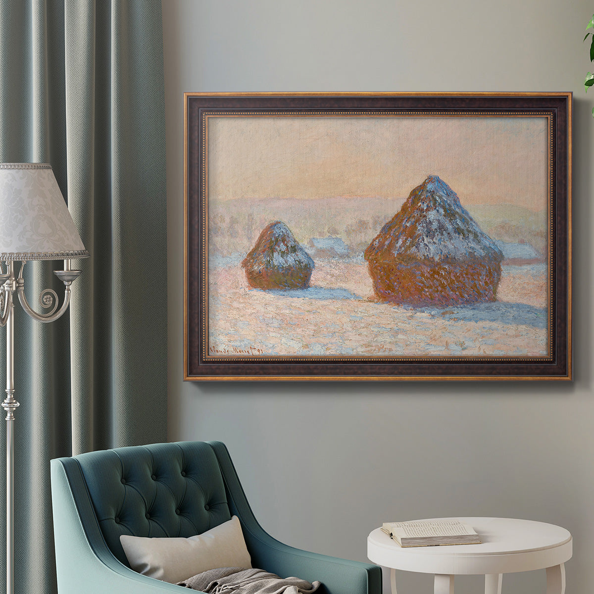Impressionist winter haystack scene by Claude Monet in an ornate bronzed mahogany wood frame displayed in a bright interior setting.