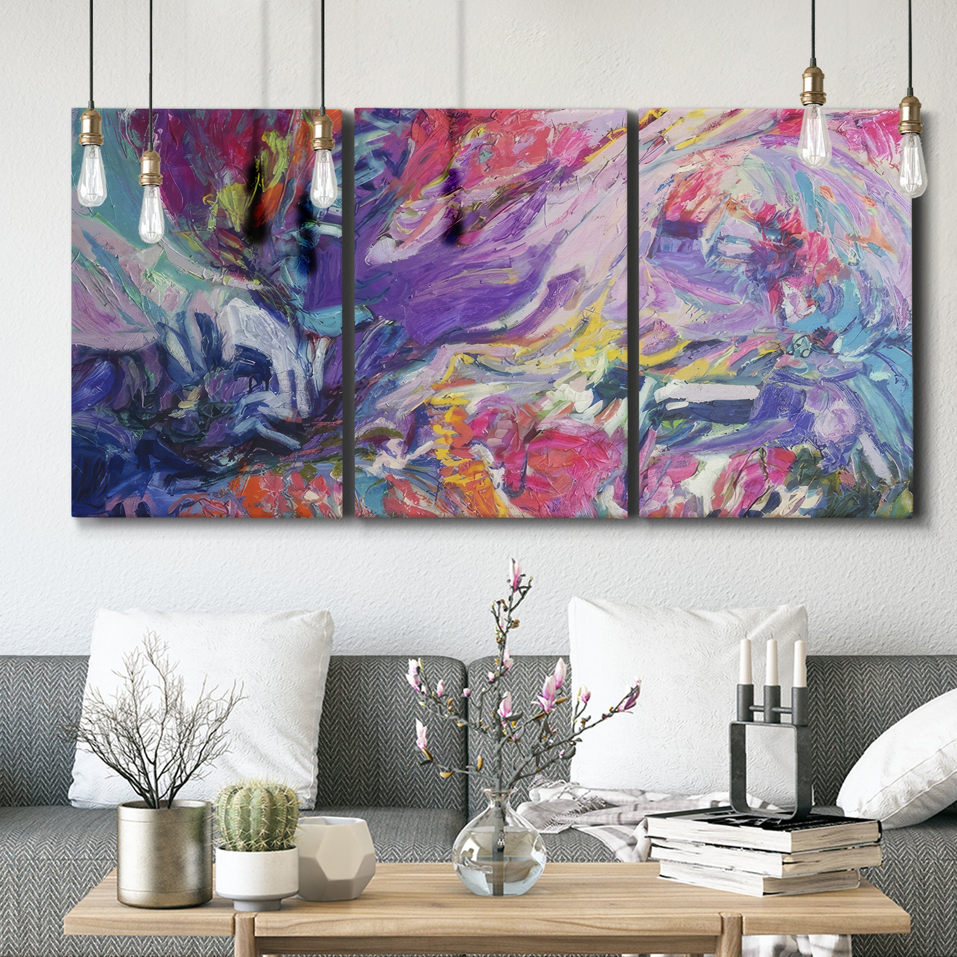 Three-panel canvas wall art featuring expressive abstract with layered color, displayed in a modern living room above seating.