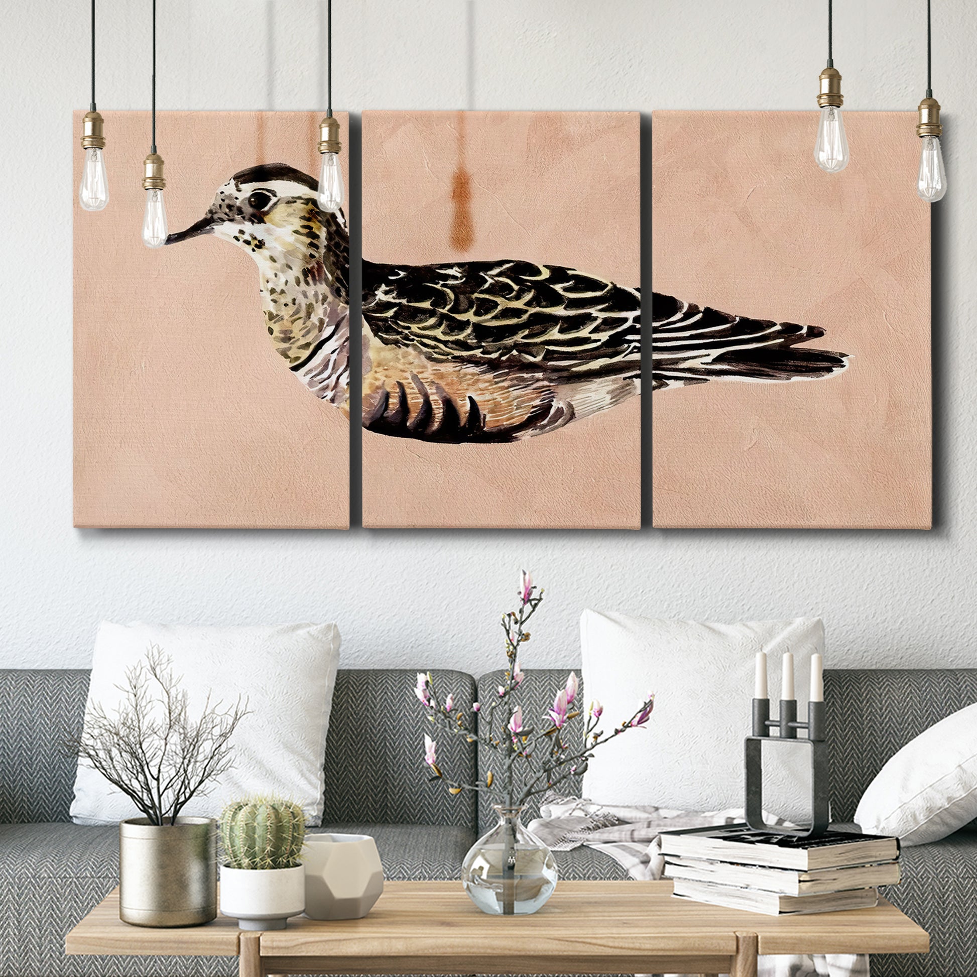 Three-panel canvas wall art featuring coastal bird illustration, displayed in a modern living room above seating.