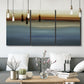 Three-panel canvas wall art featuring horizontal abstract coastal color bands, displayed in a modern living room above seating.