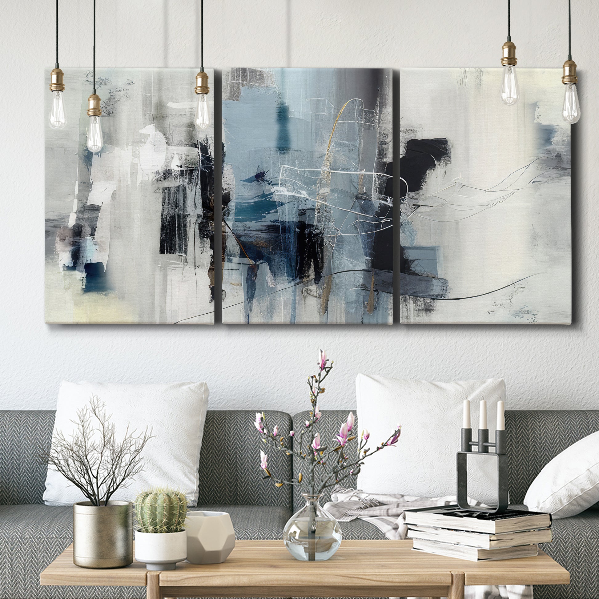 Three-panel canvas wall art featuring cool abstract winter color wash, displayed in a modern living room above seating.