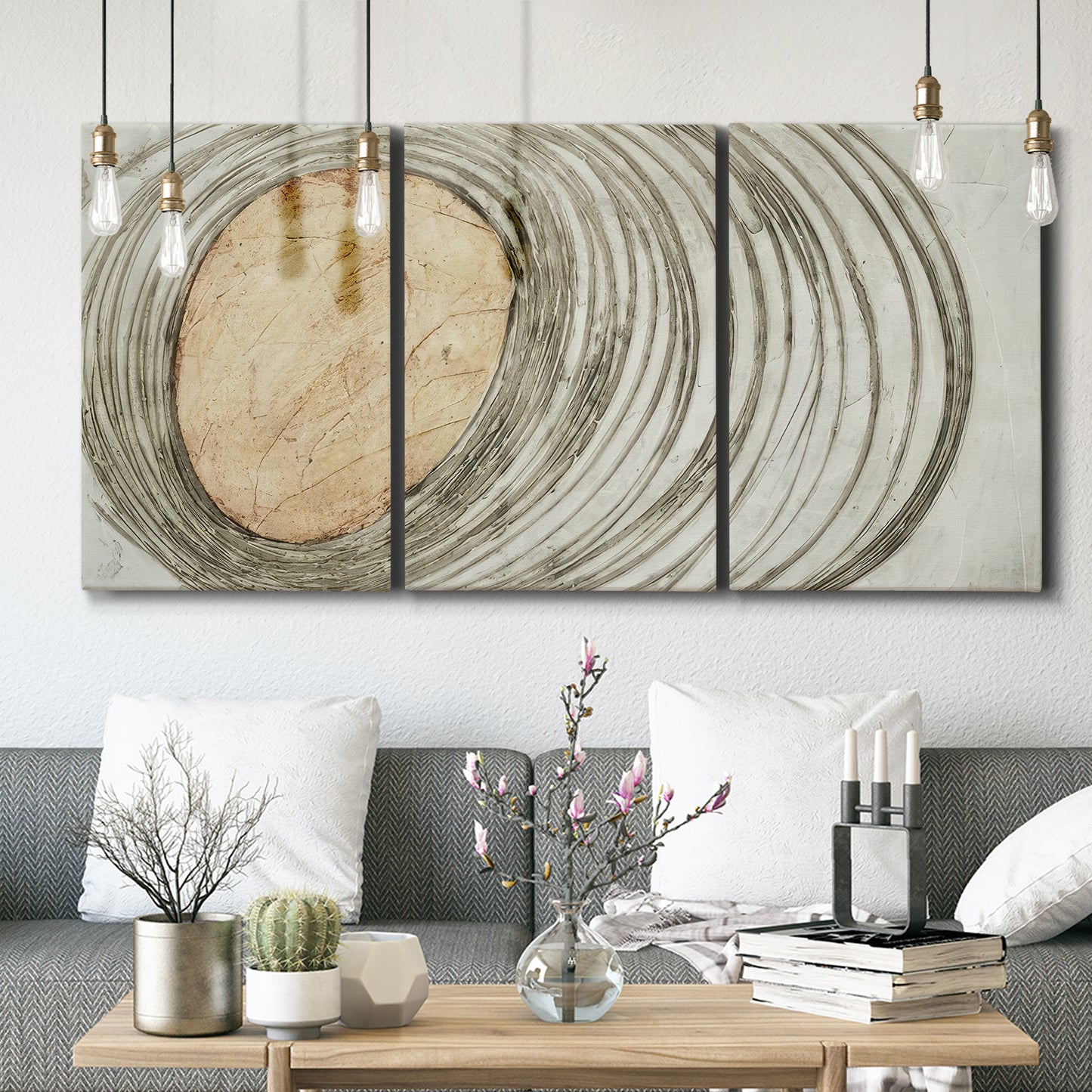 Three-panel canvas wall art featuring circular abstract energy forms, displayed in a modern living room above seating.