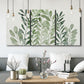 Three-panel canvas wall art featuring foraged leafy greens botanical study, displayed in a modern living room above seating.