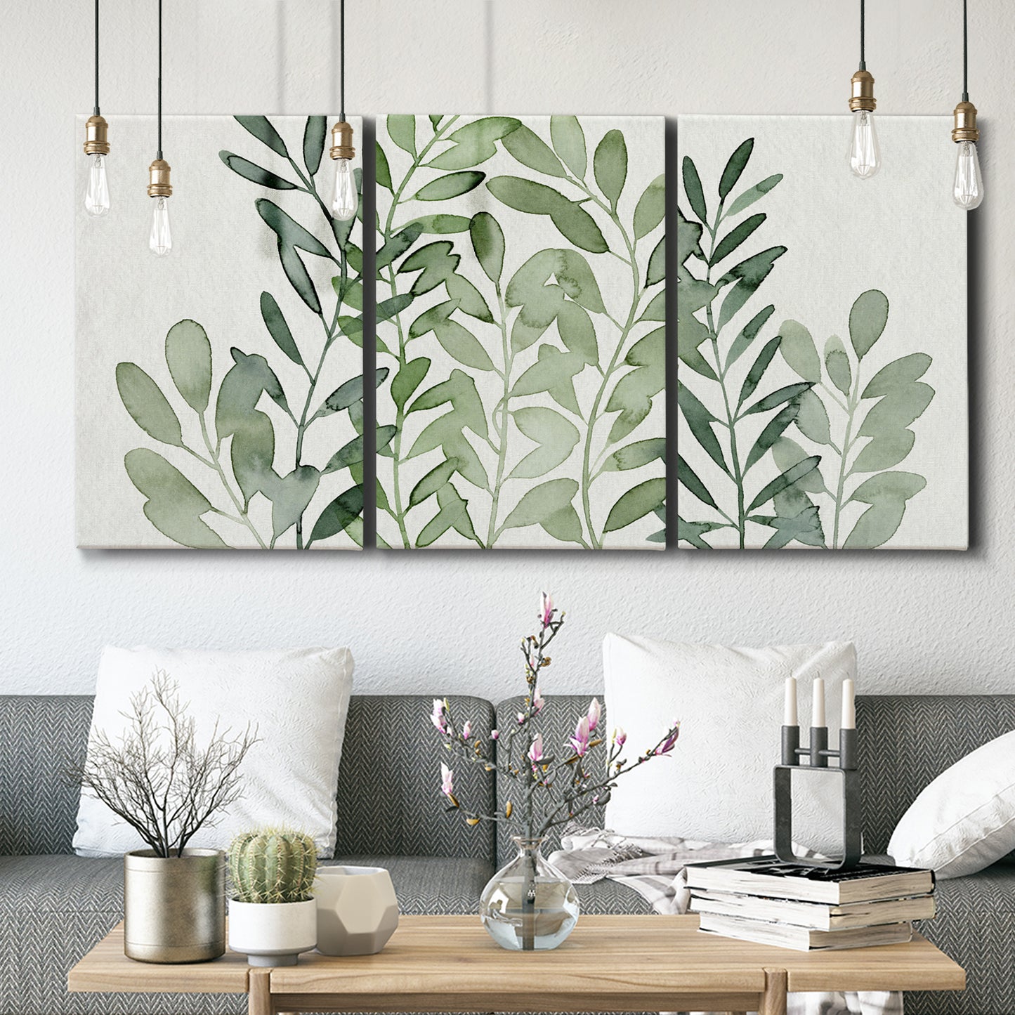 Three-panel canvas wall art featuring foraged leafy greens botanical study, displayed in a modern living room above seating.