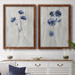Set of two maple barnwood framed canvas prints depicting a coordinated art pair of blue wildflower stems on weathered neutral paper rendered as rustic monochrome botanical paintings above a dining room sideboard.