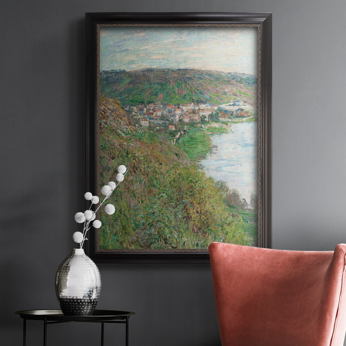 Impressionist landscape view of Vétheuil by Claude Monet in an ornate black frame with gilded inner detail displayed in a dark-toned interior setting.