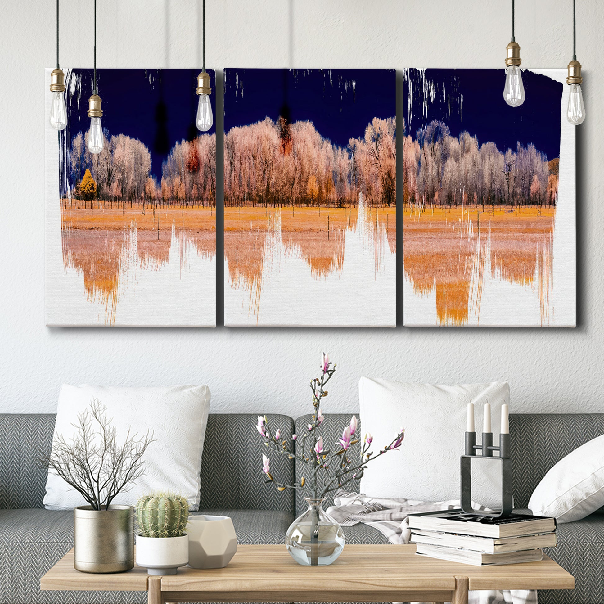 Three-panel canvas wall art featuring panoramic treeline landscape photograph, displayed in a modern living room above seating.