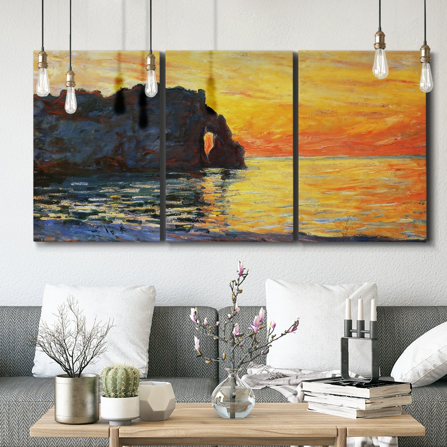 Three-panel canvas wall art featuring arched coastal cliff above sea, displayed in a modern living room above seating.