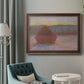 Impressionist haystack sunset scene in winter by Claude Monet in an ornate bronzed mahogany wood frame displayed in a bright interior setting.