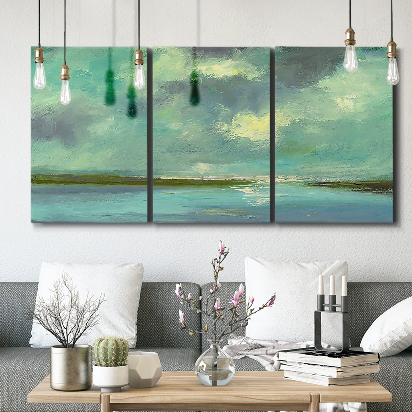 Three-panel canvas wall art featuring still lagoon water beneath open sky, displayed in a modern living room above seating.