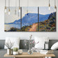 Three-panel canvas wall art featuring winding coastal road above sea, displayed in a modern living room above seating.