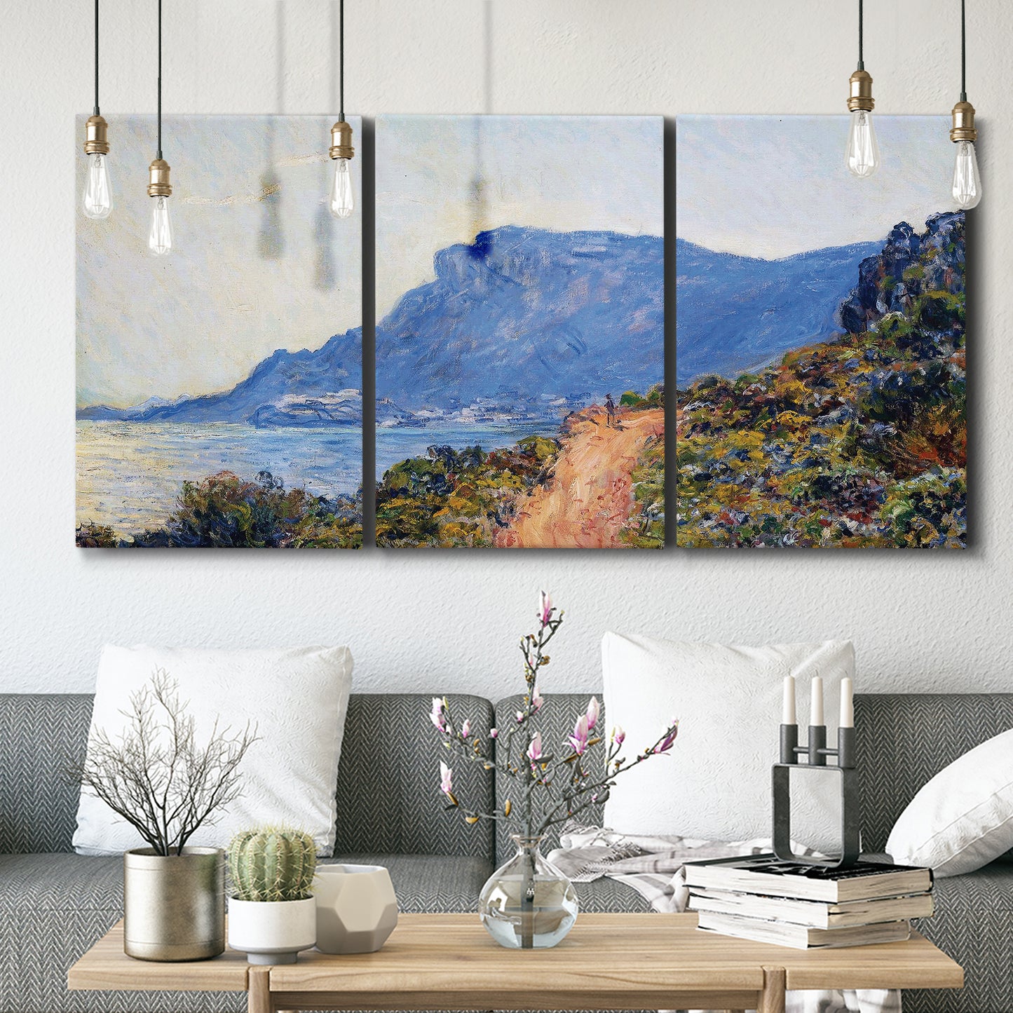 Three-panel canvas wall art featuring winding coastal road above sea, displayed in a modern living room above seating.