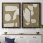 Set of two black barnwood framed canvas prints depicting a coordinated art pair of irregular white cutout-like shapes on taupe grounds rendered as bold minimalist shape abstracts above a dining room sideboard.