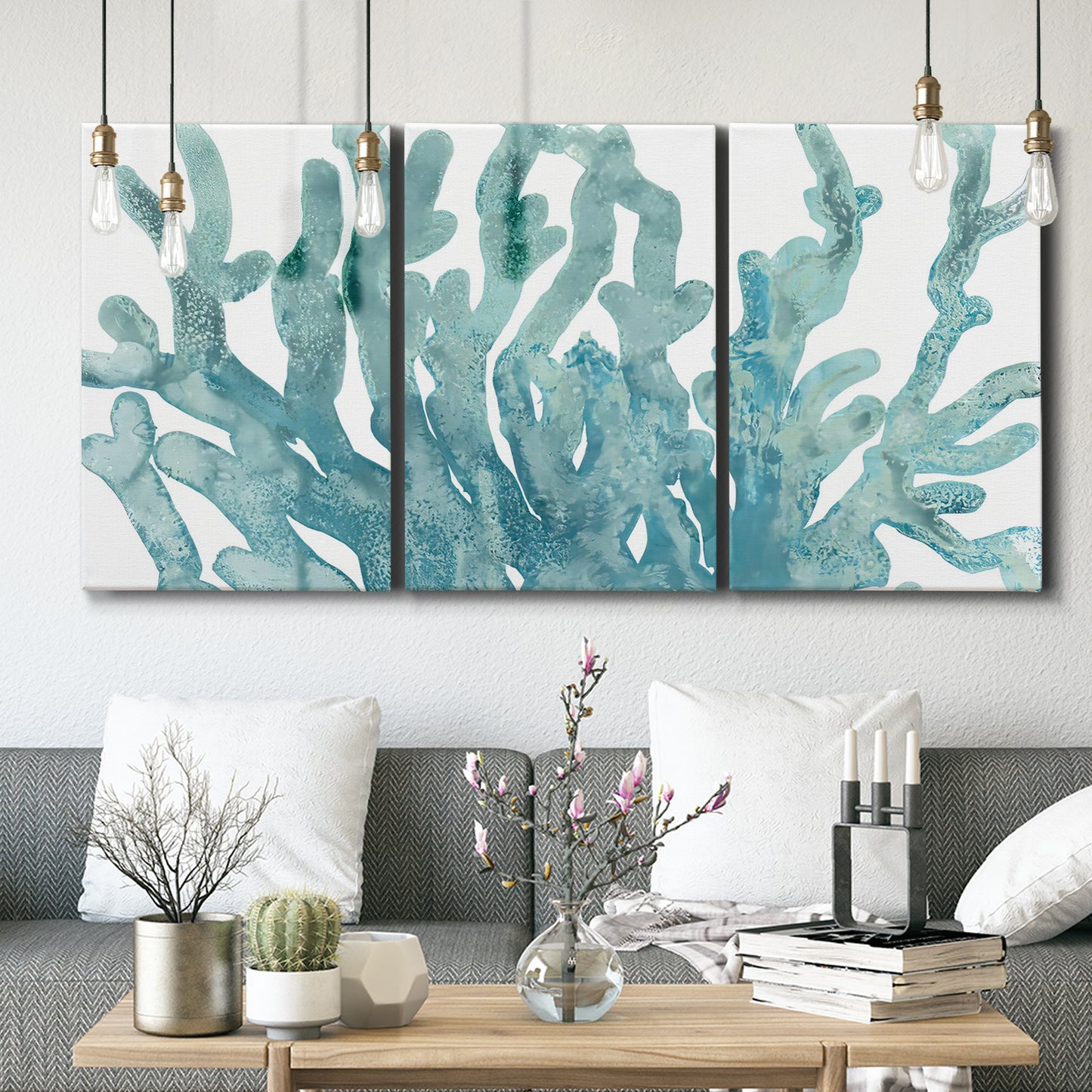 Three-panel canvas wall art featuring blue coral inspired watercolor, displayed in a modern living room above seating.