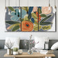 Three-panel canvas wall art featuring colorful botanical illustration, displayed in a modern living room above seating.