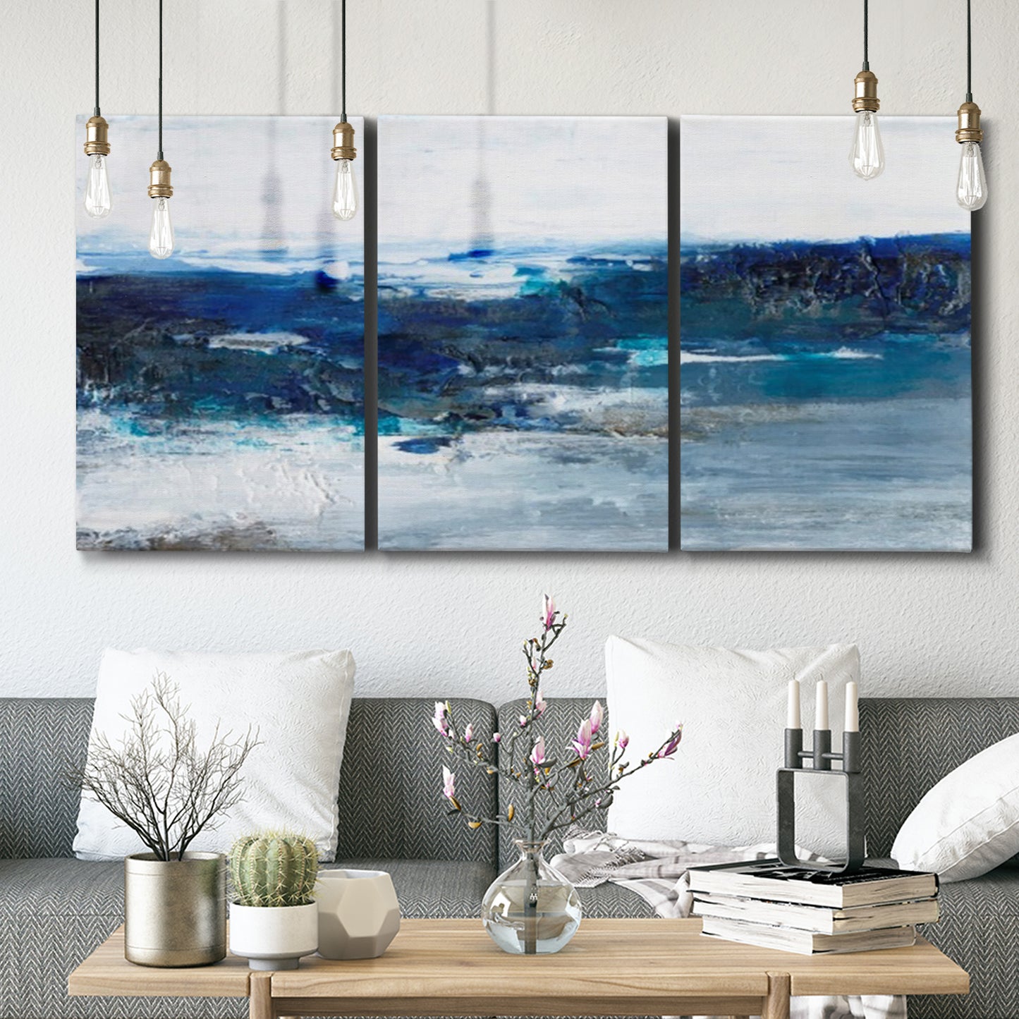 Three-panel canvas wall art featuring moody abstract sea with depth, displayed in a modern living room above seating.