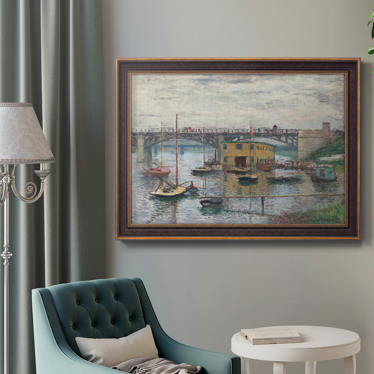 Impressionist river bridge scene on an overcast day by Claude Monet in an ornate bronzed mahogany wood frame displayed in a bright interior setting.