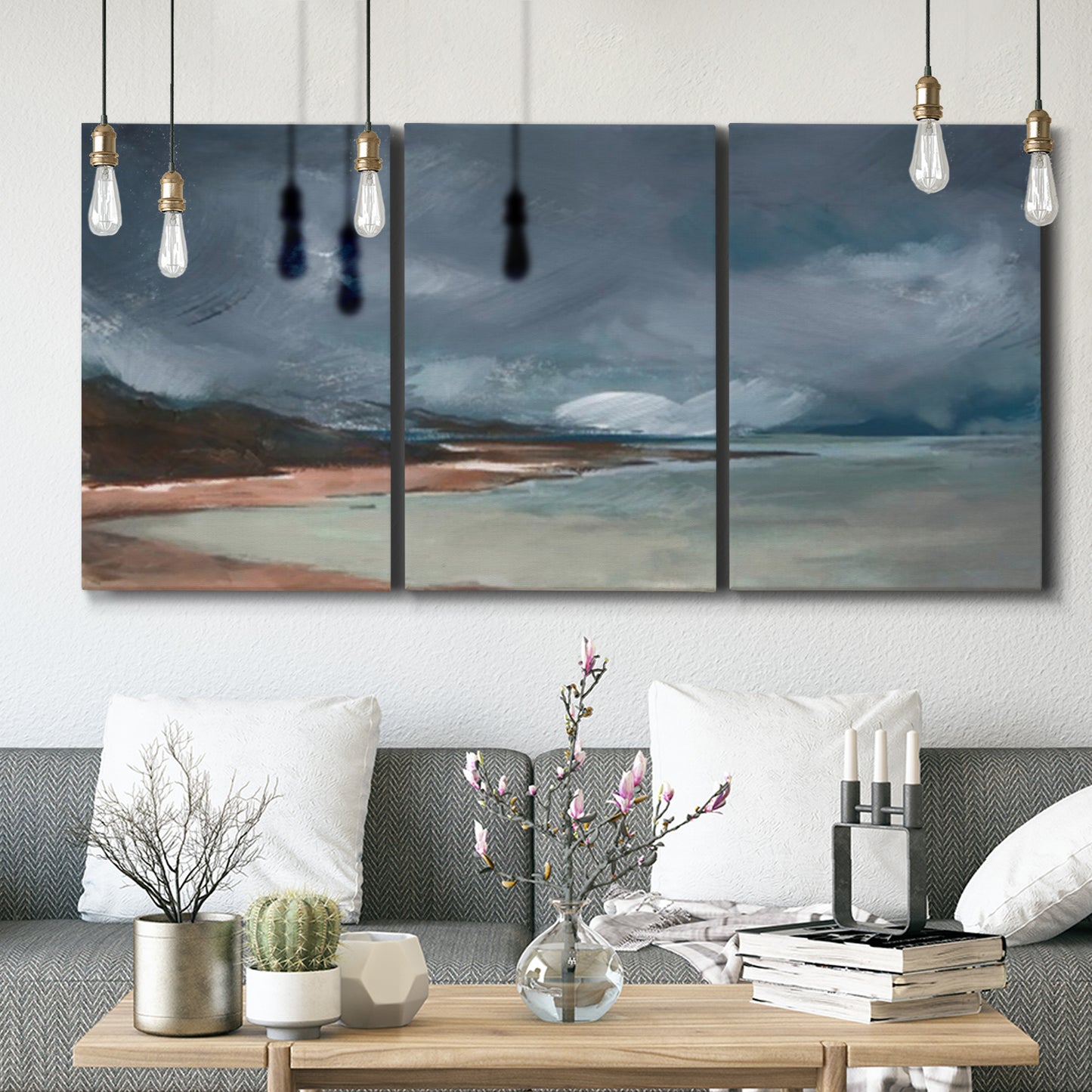 Three-panel canvas wall art featuring stormy sea glass toned coastline, displayed in a modern living room above seating.