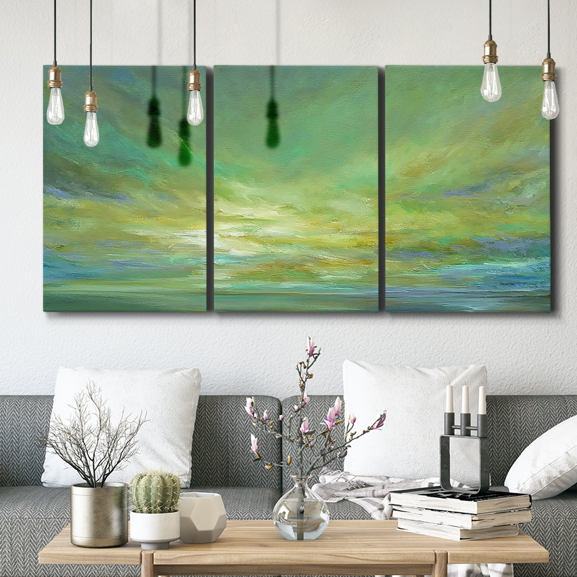 Three-panel canvas wall art featuring coastal shoreline under open sky, displayed in a modern living room above seating.