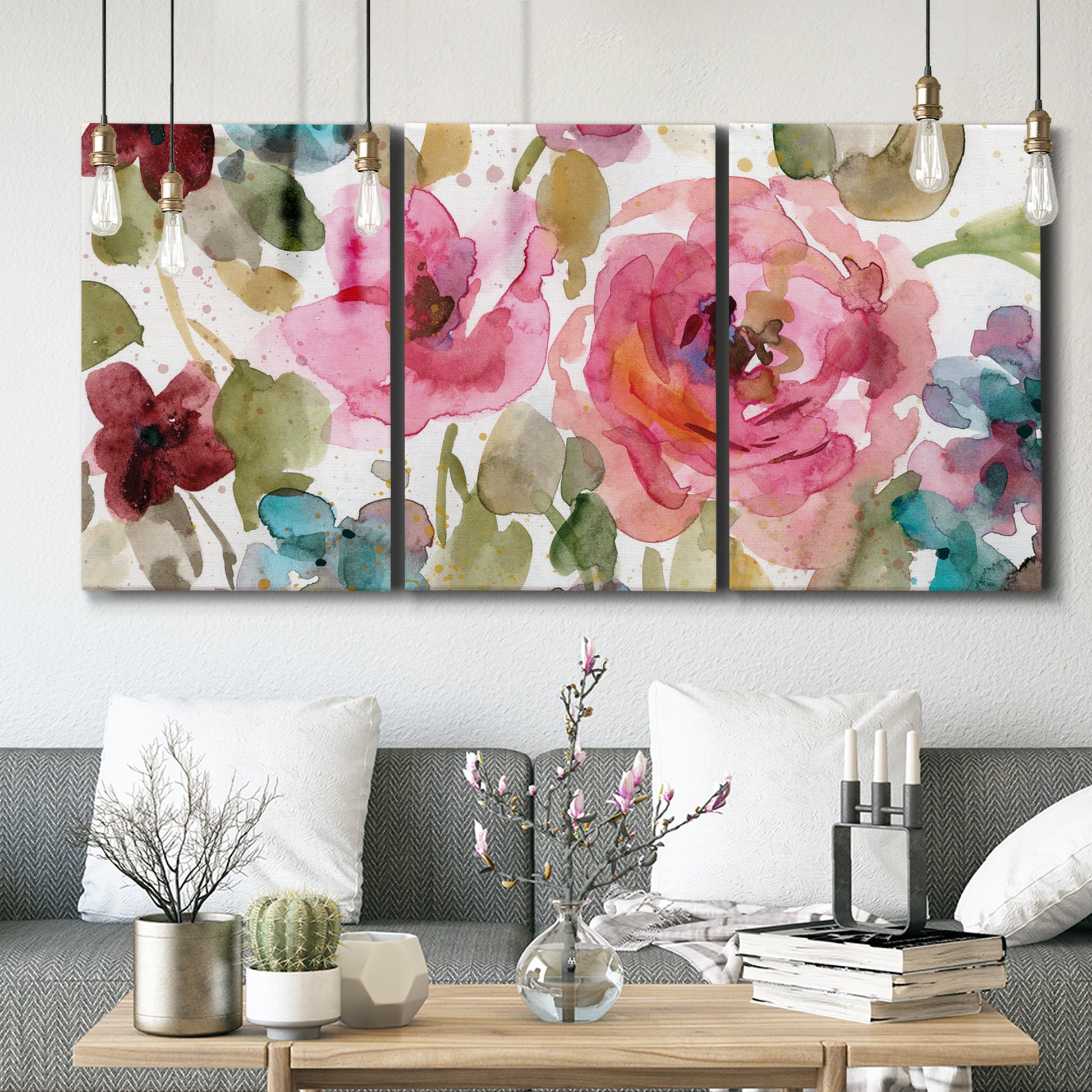 Three-panel canvas wall art featuring colorful floral watercolor composition, displayed in a modern living room above seating.