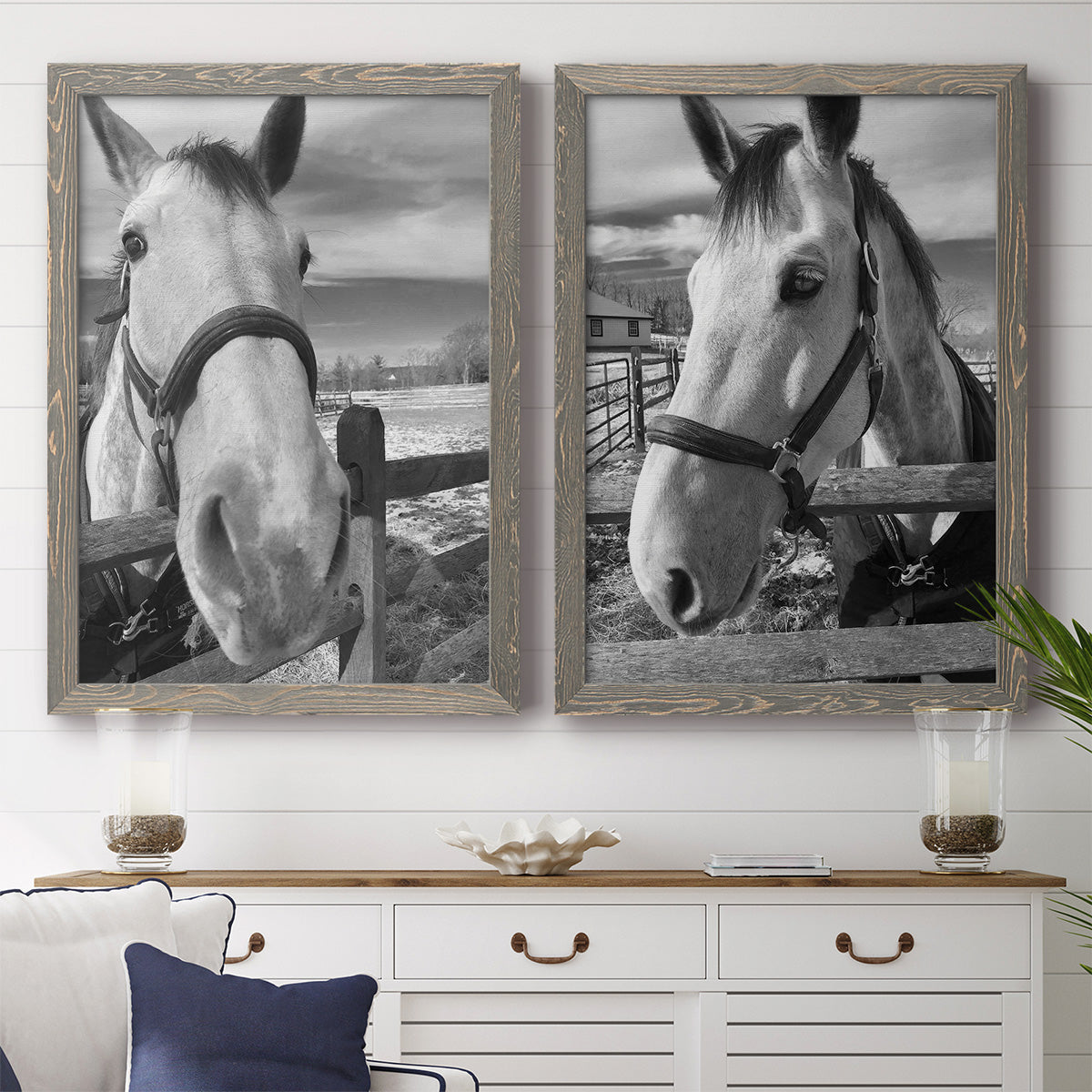 Set of two gray barnwood framed canvas prints depicting a coordinated art pair of black-and-white close-up portraits of horses at fences rendered as modern equestrian photography above a dining room sideboard.