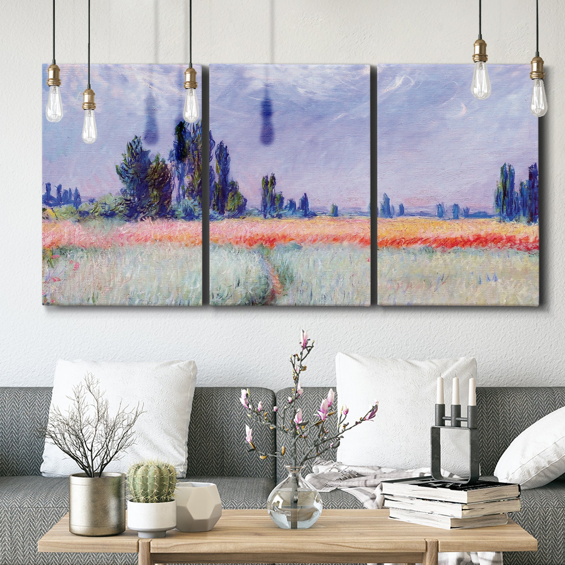Three-panel canvas wall art featuring flowering field with poppies, displayed in a modern living room above seating.